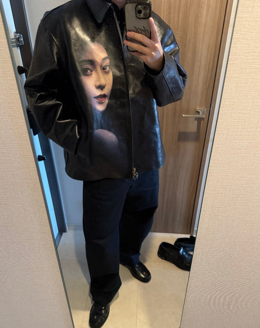 Streetwear outfit with black leather jacket featuring a woman's face graphic, donclickin style