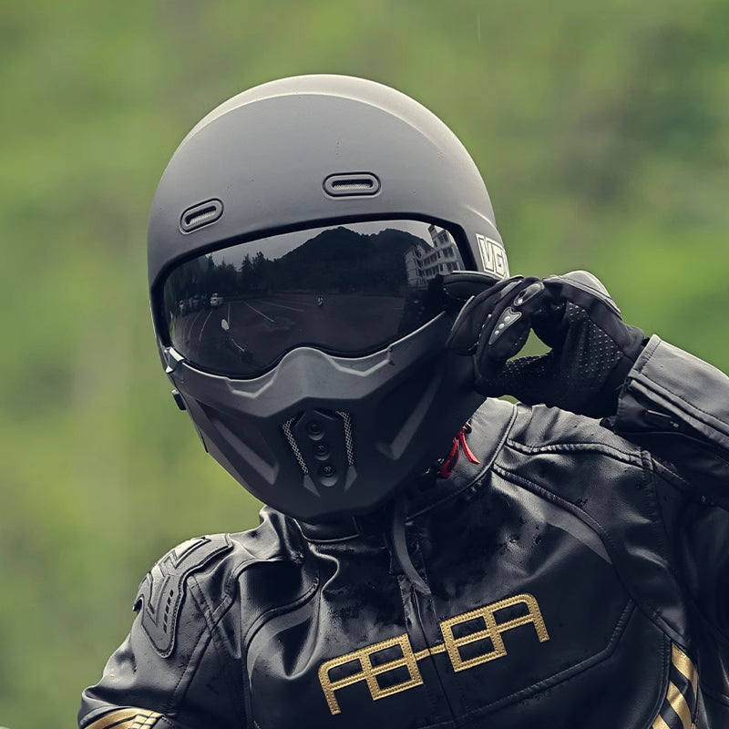 Streetwear-inspired motorcyclist in matte black helmet, goggles, and black leather jacket