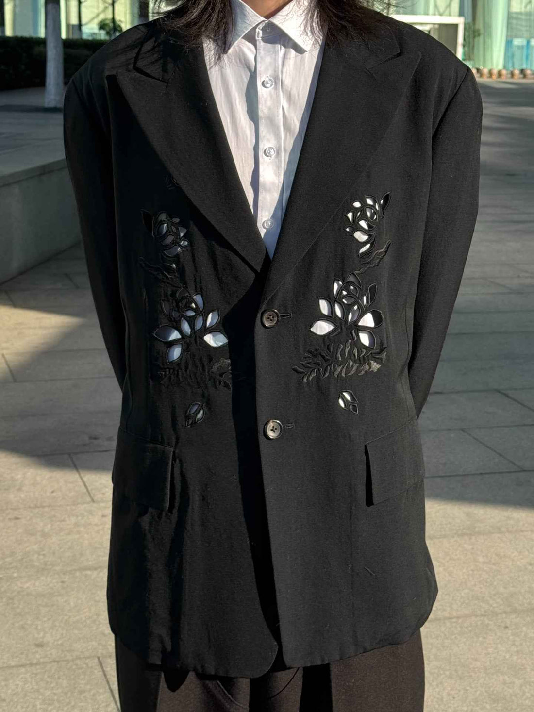 Streetwear black blazer with floral cutouts over white shirt, outdoor urban setting, donclickin