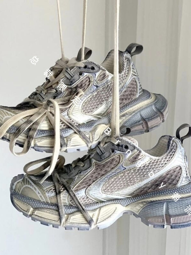 Chunky beige and grey streetwear sneakers hanging by laces, modern style, donclickin